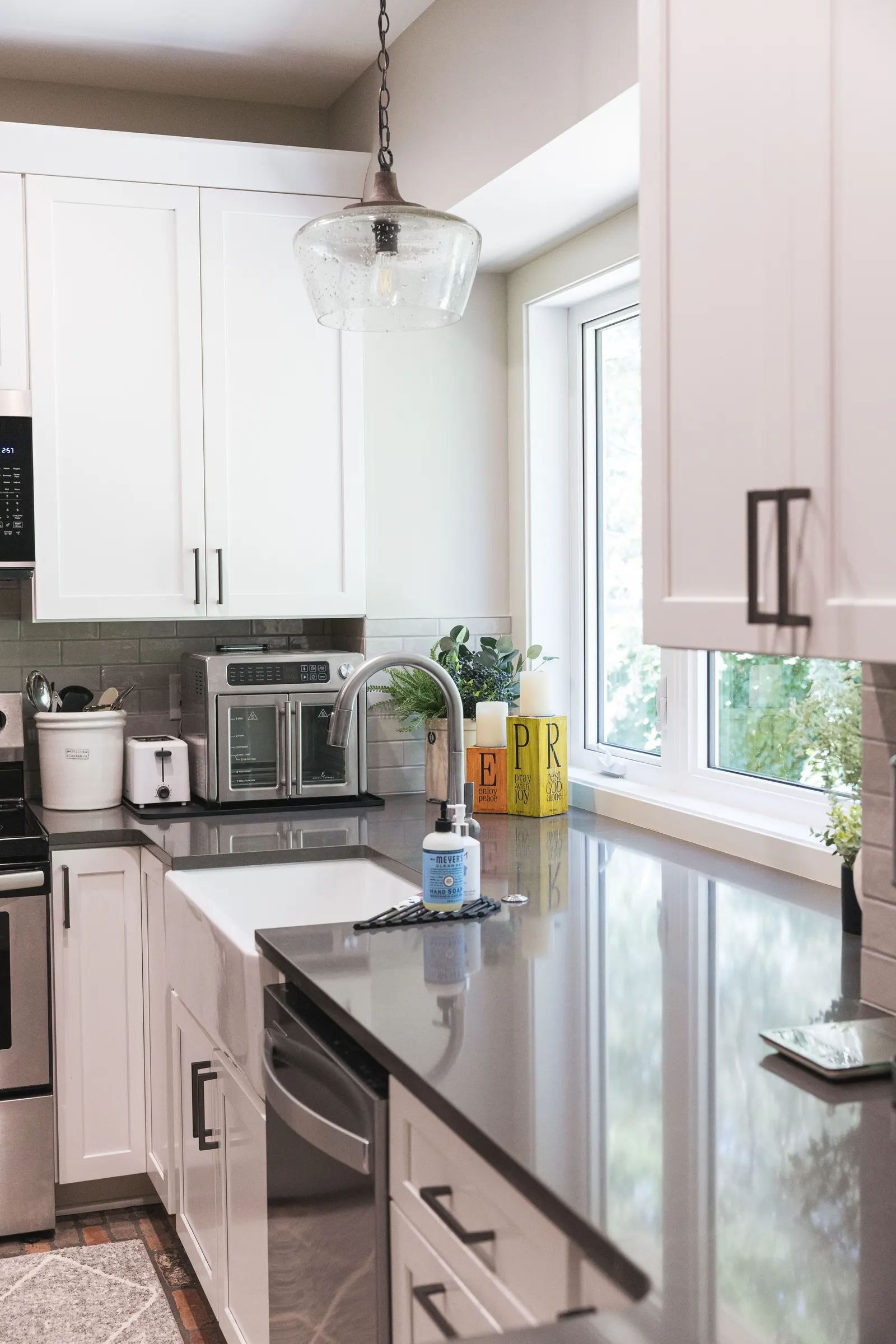 The stainless range and microwave set into white shaker cabinets.