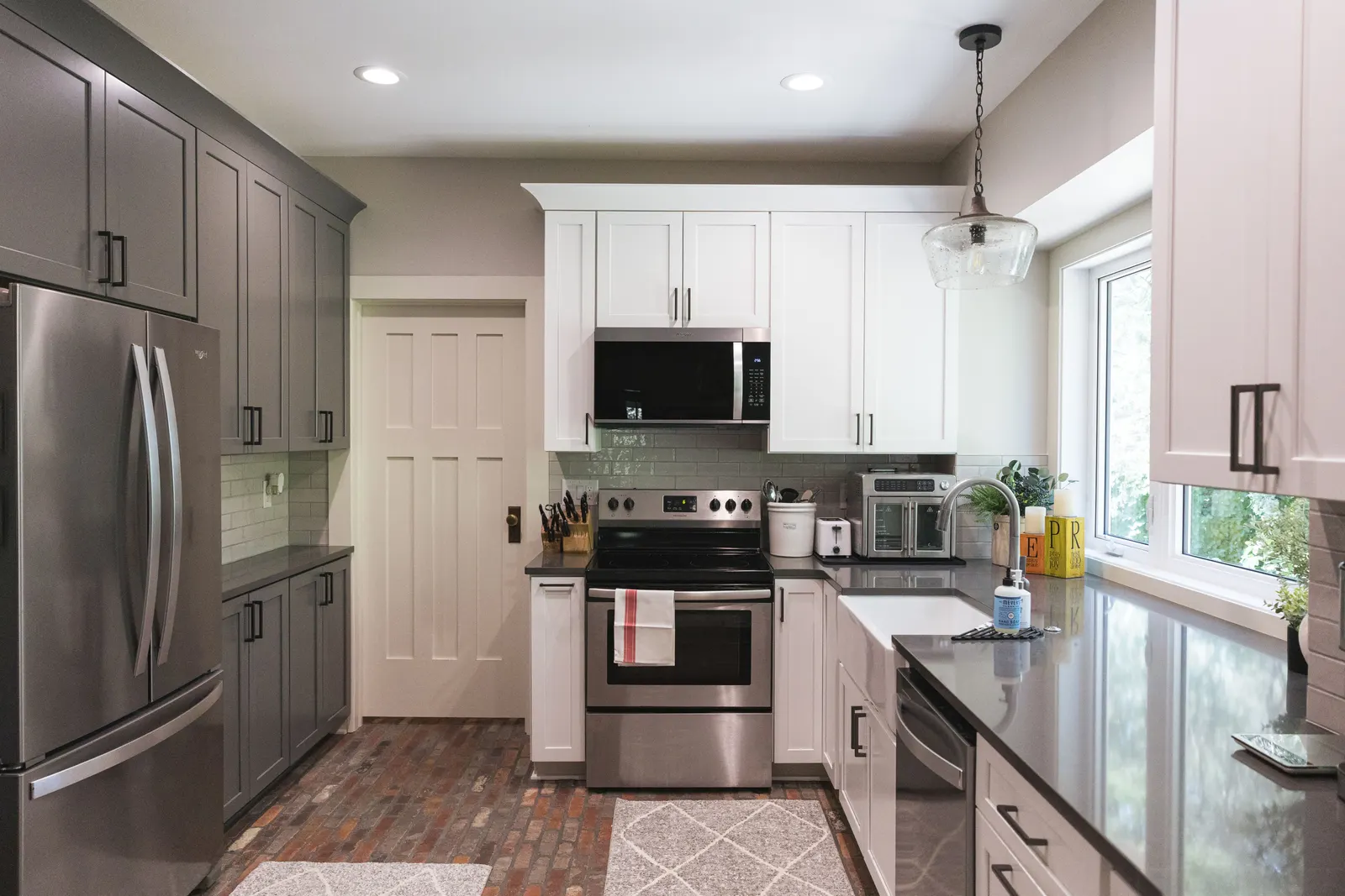 The range wall with gray tall cabinets on the left and white upper cabinets on the right.
